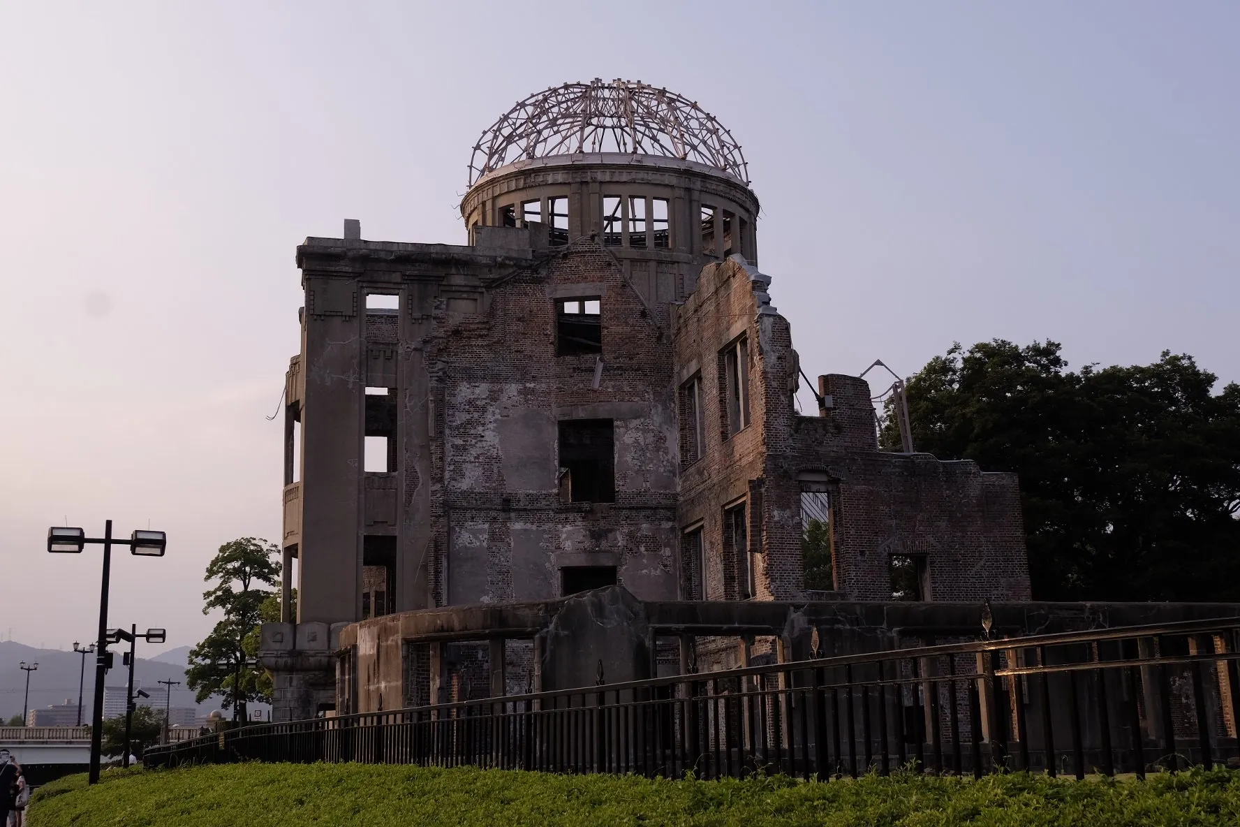 The gutted brick shell and bare steel dome of the Genbaku Dome against a pale evening sky