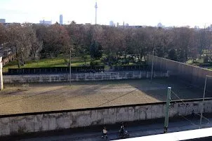 A preserved stretch of the wall and its raked sand strip, seen from above with the city beyond