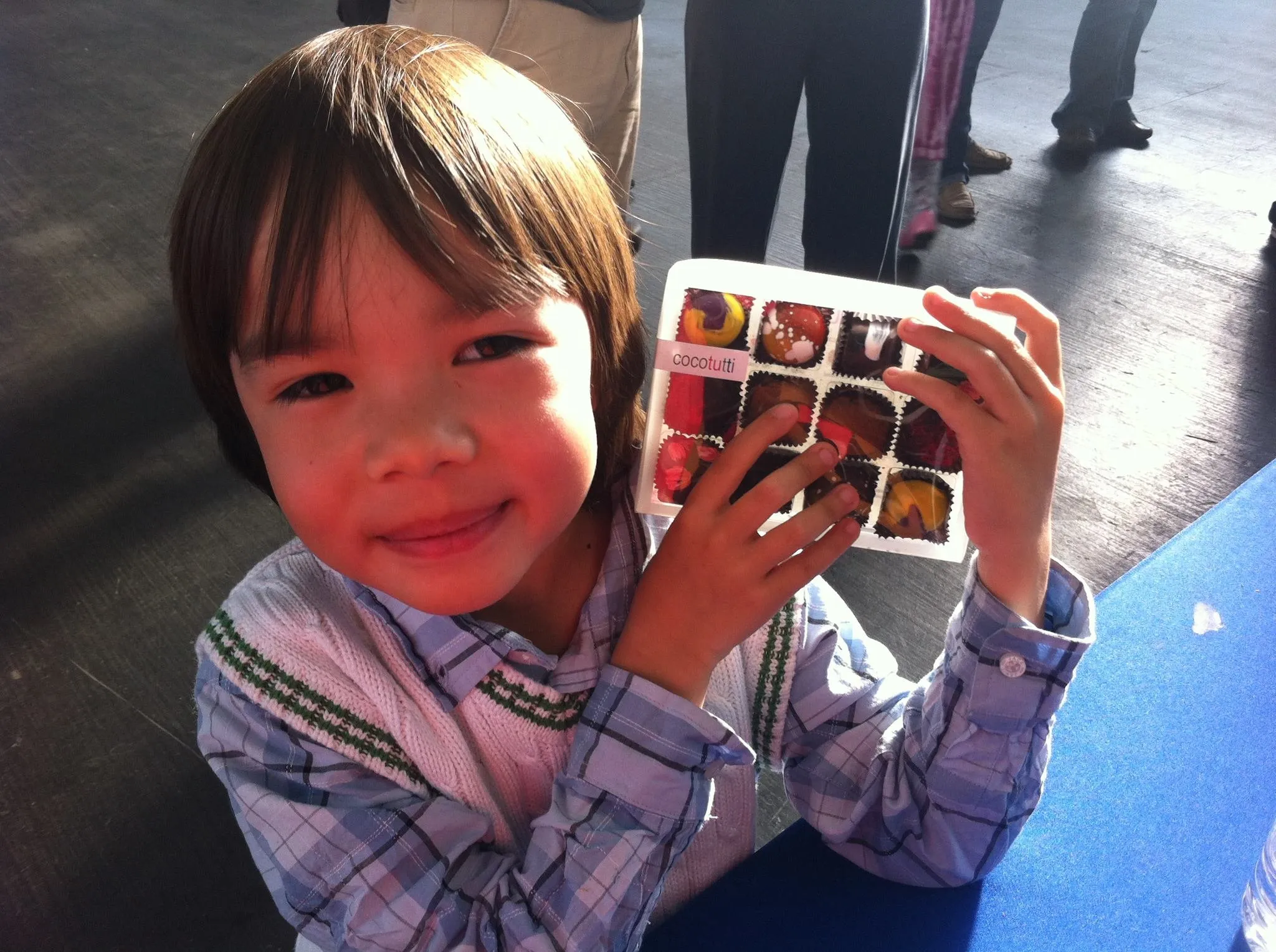 Me as a small boy at a chocolate festival, holding up a boxed assortment of truffles with both hands