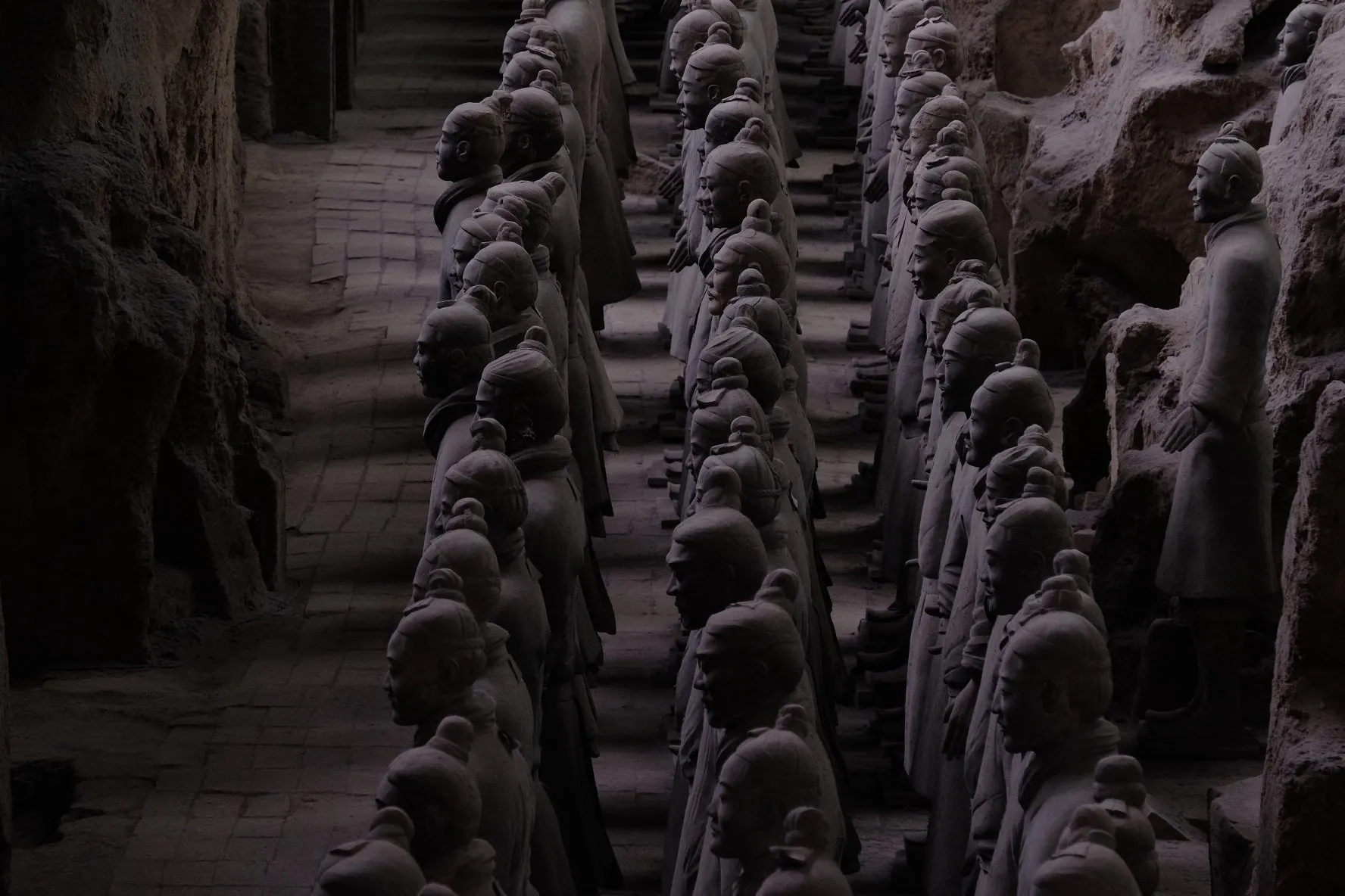 Rows of terracotta soldiers standing in the excavated earthen trenches