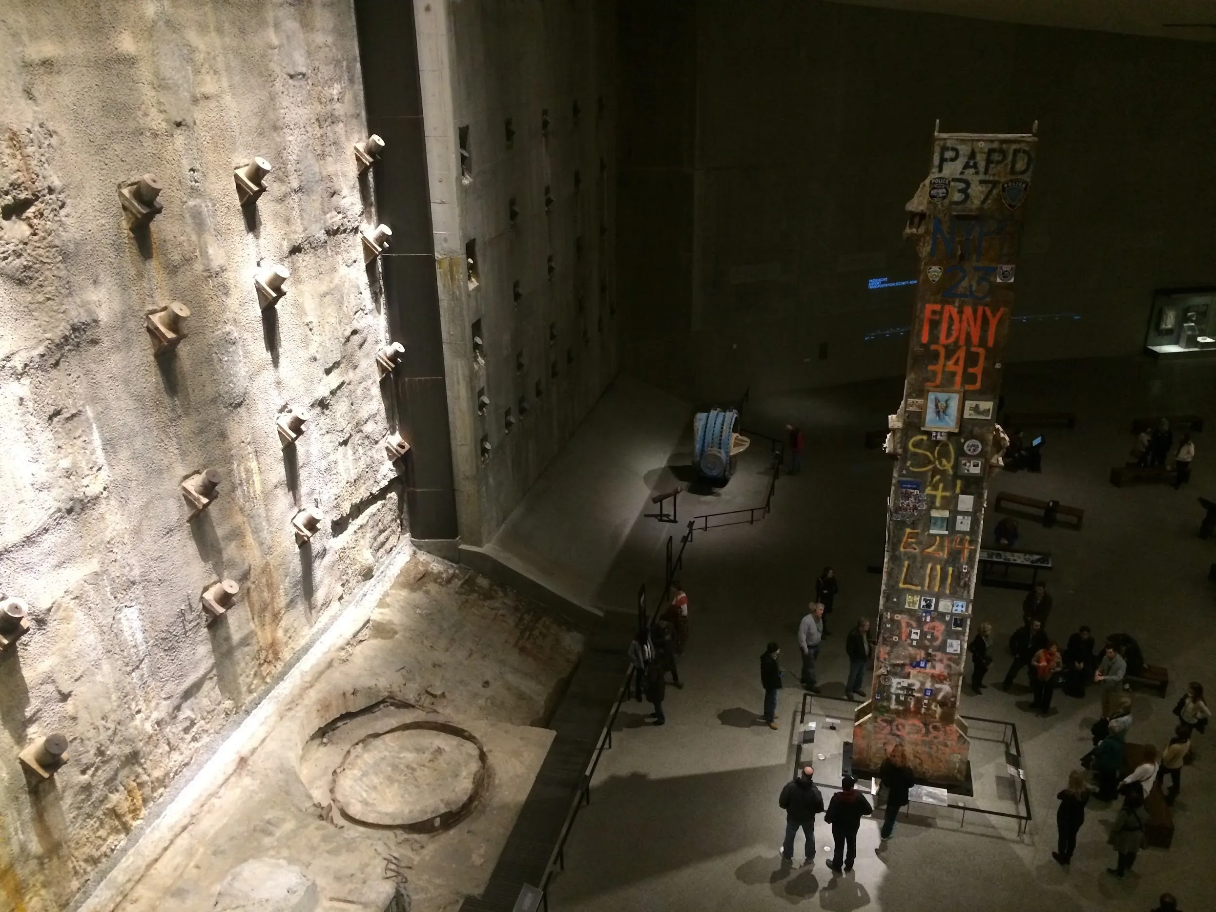 The slurry wall and a memorial column covered in written tributes inside the museum’s cavernous hall